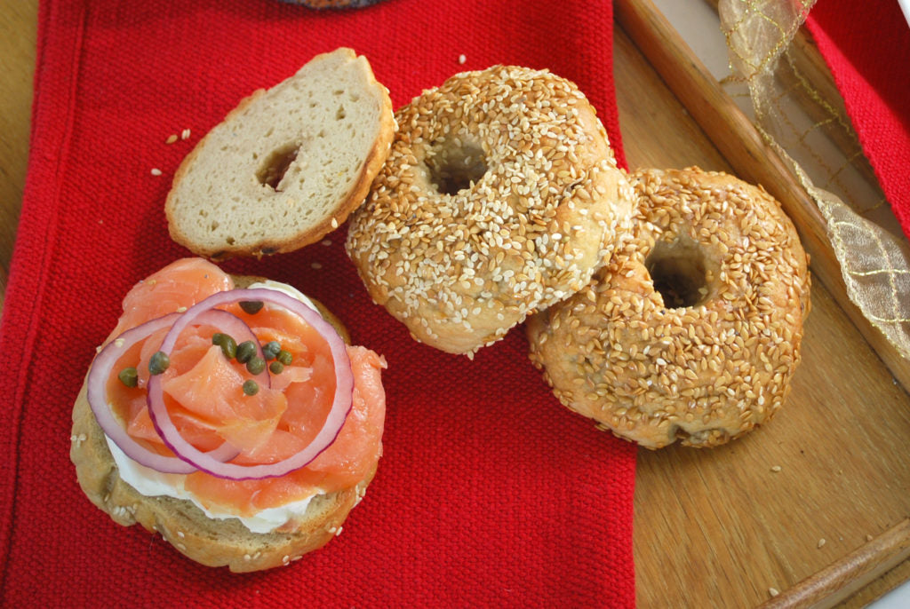 Homemade gluten-free bagels on a baking sheet, golden and chewy