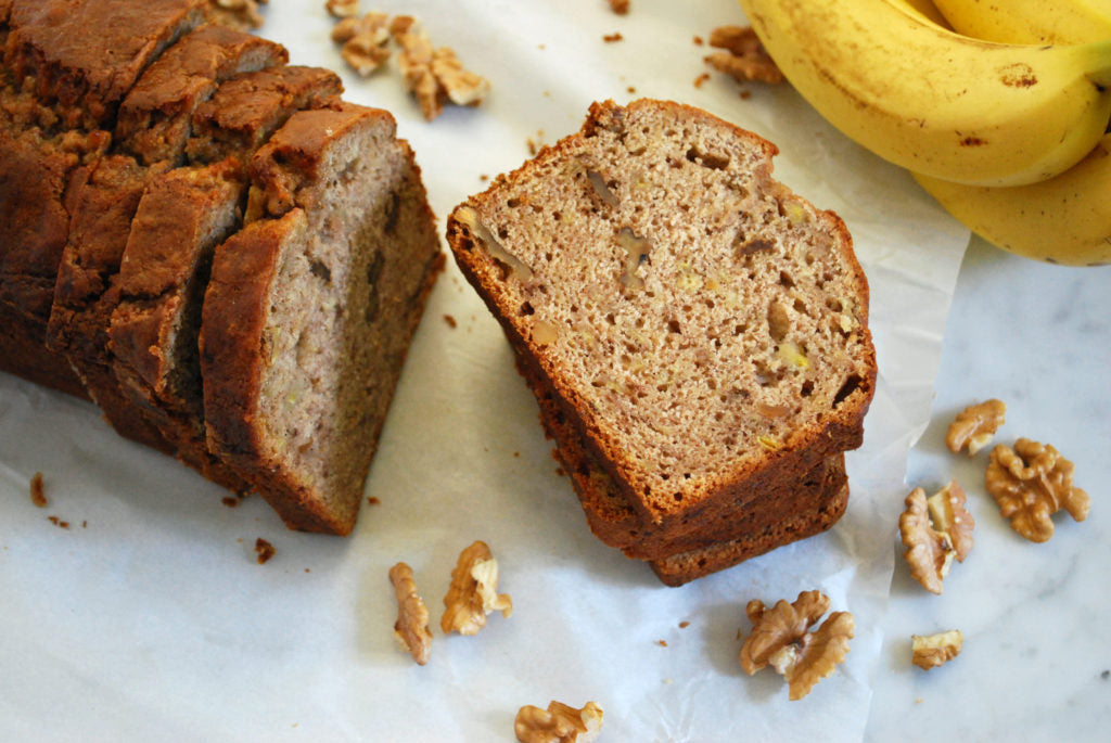 Gluten-free banana bread loaf made with Pamela's 1:1 All-Purpose Flour, sliced on a board