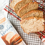 Sliced loaf of bread on a cooling rack with Pamela's Bread Mix packaging.