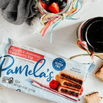 Pamela's cookies package on a table with a jar of berries and a cup of coffee.
