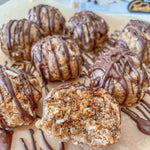 Chocolate-dipped cookies on a plate with a visible brand logo in the background.